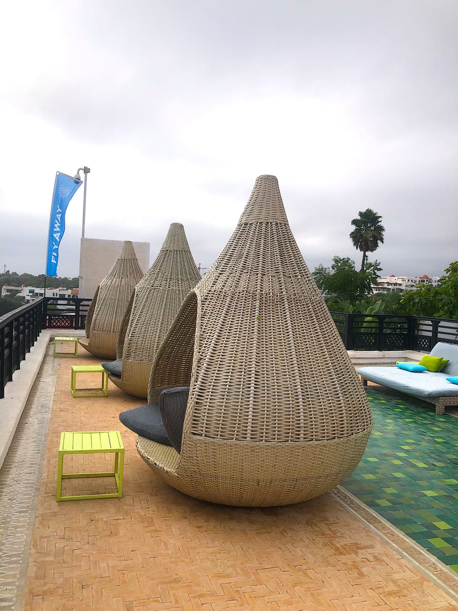 Cabañas de mimbre junto a la piscina y la terraza del resort