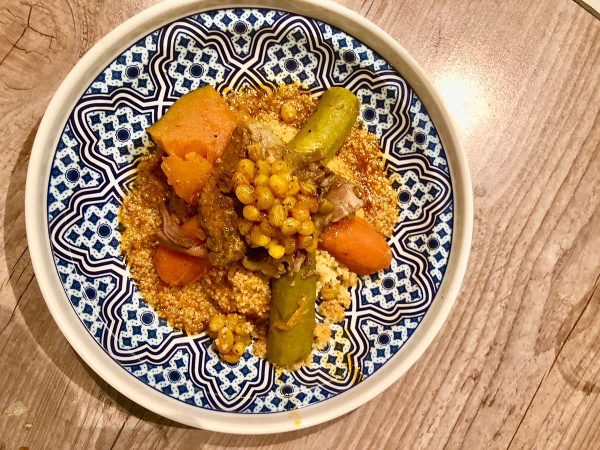 Plato de cuscús con verduras servido en cerámica marroquí